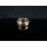 An 18ct gold wedding band, 7mm wide. Size T, 6.