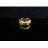 A 22ct gold engraved band. Size K, 5.