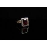 A 9ct gold ring the central emerald cut dark orange stone framed by diamonds in rectangular mount.