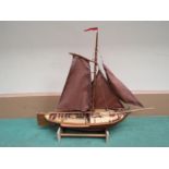 A hand built wooden model of a tradional Zuiderzee fishing boat with cloth sails, on stand,