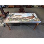 A coffee table with scenes of pheasants made from feathers