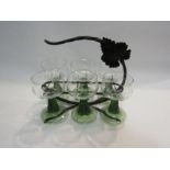 A set of green stem wine goblets with grape and vine etched design together with a metal carrying