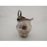 A Georgian silver cream jug with engraved detail, monogrammed MD, dented, 84g, London 1802