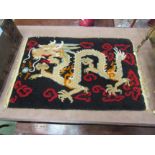 A hand woven Tibetan floor rug converted to a wall hanging depicting dragon chasing the flaming