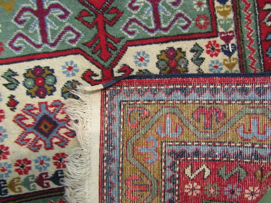 A red ground wool prayer rug with multiple borders, geometric shape to centre, 146cm x 91cm - Image 2 of 2