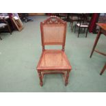 A set of eight oak dining chairs with carved back rests and cane backs and seats on turned 'H'