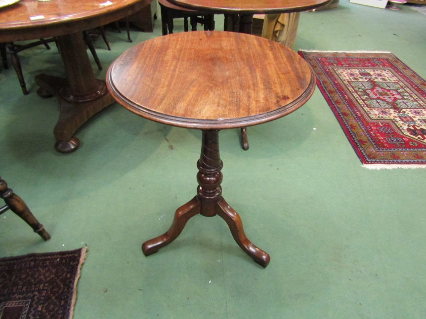 A mid Victorian walnut circular top wine table over a turned and spiral column on a tripod base.