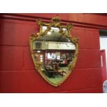 A gilt classical wall mirror of ornate shield form, damage present, 72cm x 53cm