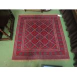 A square rug with diamond geometric patterned centre on red ground 125 x 125cm