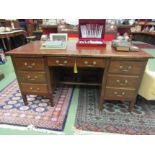 Circa 1950 a dark oak twin pedestal desk with brushing slides over six drawers and central drawer
