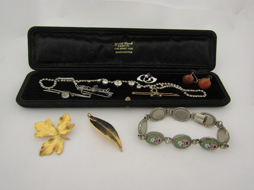 A selection of costume jewellery incluidng mosaic panel bracelet, gold bar brooch, gilt brooches,