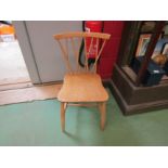 An Ercol pine single chair with cross-splat back on stretcher base