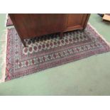 Two geometric design rugs with multiple borders, navy and turquoise ground with tasselled ends.