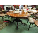 Circa 1860 a burr walnut quarter veneer oval tilt top table on a turned and carved base with