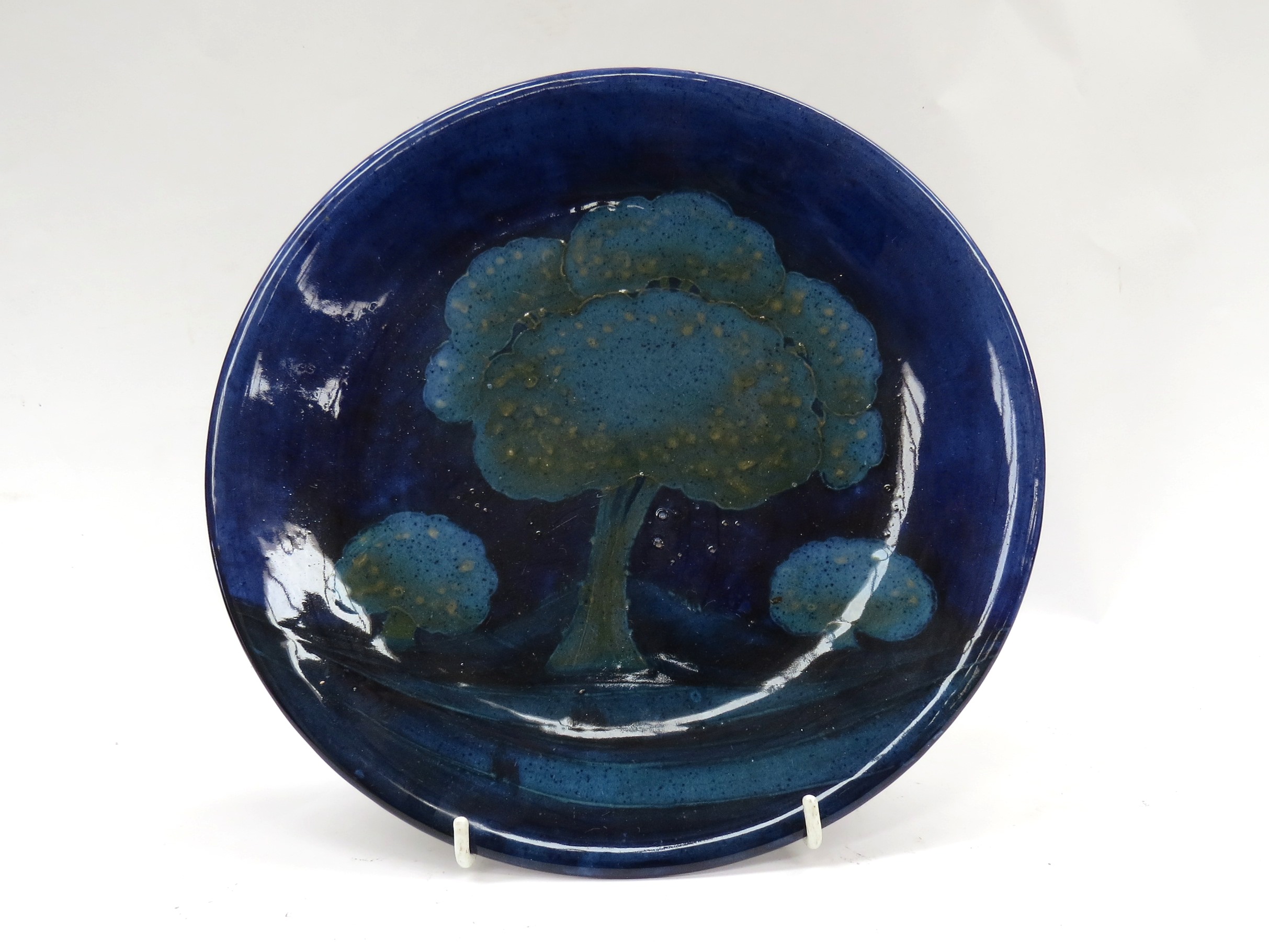 A William Moorcroft 'Moonlit Blue' pattern charger with tree design,