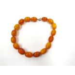 A butterscotch amber bead necklace, with good size oval beads 23mm x 15mm, 41cm long, 60.