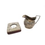 A 19th Century silver creamer, floral body, stirrup handle, marks rubbed.