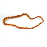 A graduated row of cognac amber beads with natural internal inclusions to the larger beads, 50g,