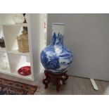 A pair of Chinese blue and white bottle vases, hand painted landscapes, 23" high with wooden stands,