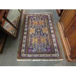 A Middle-Eastern hand woven wool rug with geometric design, two central lozenges and multiple