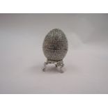 A Swarovski style enamel egg with decorative crystal drop design, on stand