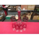 A cranberry cut glass decanter and four small glasses and two cut glass Bohemian style wine goblets