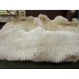 Two vintage cream sheepskin rugs