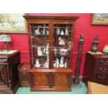 A Georgian revival flame mahogany cabinet on base the two glazed doors over a two door cupboard with