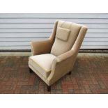 A 1940's Danish armchair with high back, stained hardwood legs, original beige velor upholstery