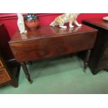 A Victorian mahogany drop flap table on barley twist legs to brass cup castors