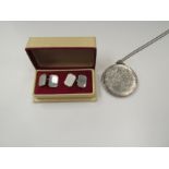 A boxed pair of silver cufflinks and a silver locket