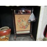 A Circa 1840 mahogany fire screen. Berlin work embroidery centre panel depicting peacock, flanked by