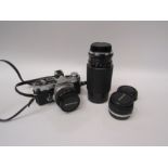 An Olympus OM-2n camera with 70-210mm lens, 1:28 lens and instruction manuals