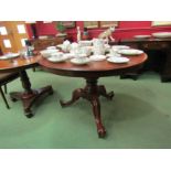 Circa 1860 a mahogany circular top table on a turned column base and scroll foot tripod legs with