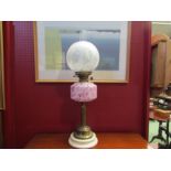 A Duplex English made oil lamp with etched glass globe shade over mottled glass reservoir, brass