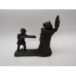 A cast metal money box in the form of man shooting bear in log