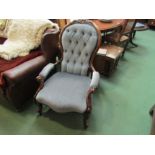 Circa 1860 a carved walnut spoon back open armchair with deep buttoning over acanthus leaf scroll