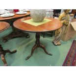 A mid George III mahogany circular tilt-top wine table over a turned and vase shape column on a