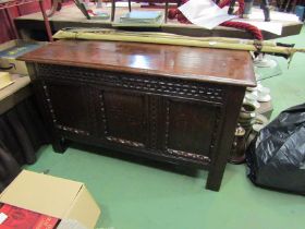 A 17th Century oak three panel coffer the hinged lid over a chip carved front on stile feet, 67cm