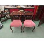 A pair of Victorian carved walnut spoon back chairs on cabriole leg supports