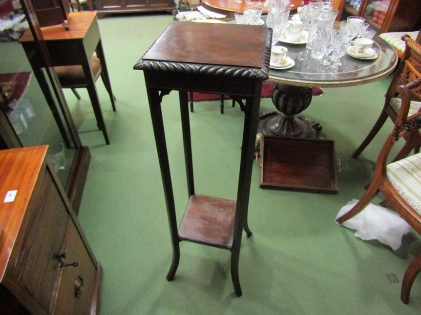 A hardwood jardiniere with carved edge top and second shelf, 107cm high