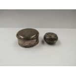 A silver pill box and a white metal dressing table pot inscribed with a crest to front and with "