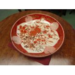 A Japanese Kutani porcelain charger, orange ground depicting flowers and birds, character marks to