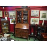 A 1930's mahogany bureau bookcase, the dentil inlaid top over astragal glazing to a fall front, twin