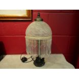 A bedside lamp with glass tasselled bead shade