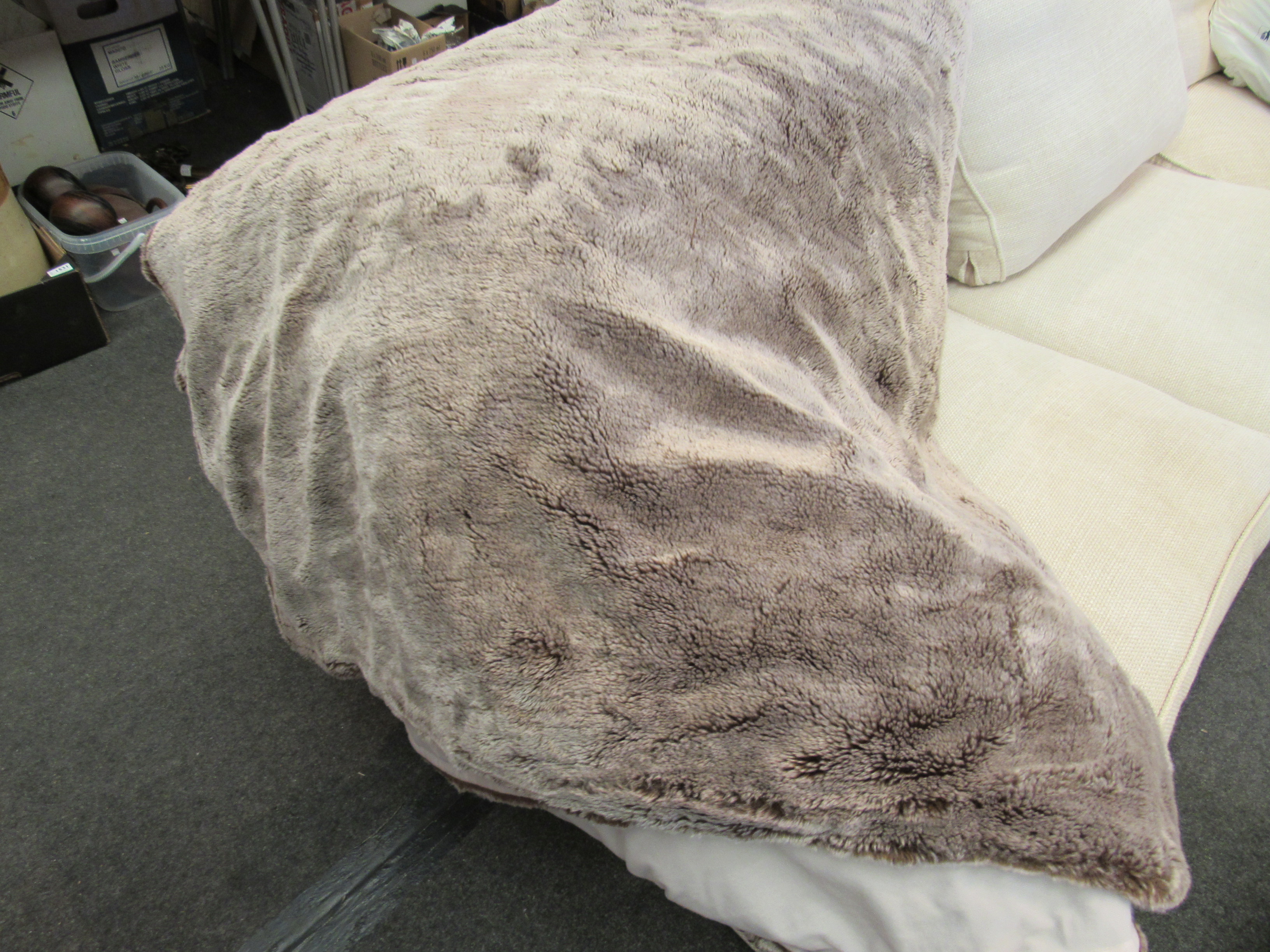 A large mushroom coloured faux fur throw