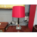A mirrored table lamp with red shade