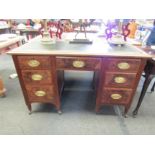 An Edwardian burr walnut desk with seven drawers on castors, leather skiver with key. 78cm x 129cm x