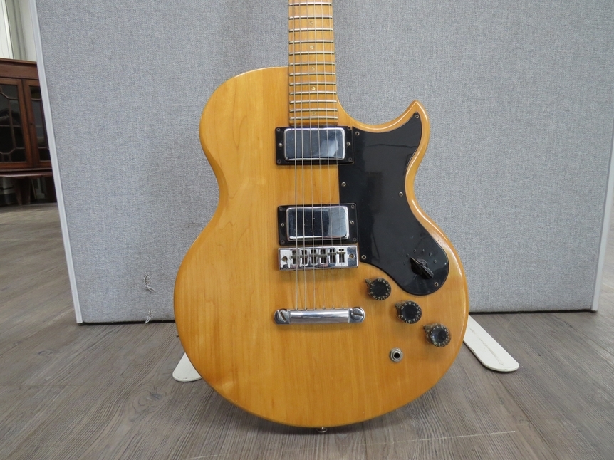 A Gibson L6-S electric guitar with maple body and neck, black pickguard, twin humbucker pickups,