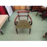 A George III Circa 1820 mahogany scroll arm elbow chair with overstuffed sage seat on turned and